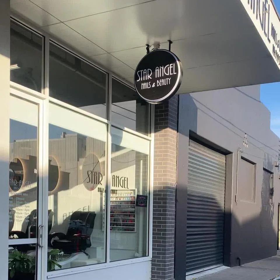 The Star Angel Nails & Beauty black, chrome-rimmed Art Deco disc sign, suspended from the shopfront at 464 High St Preston in warm afternoon light